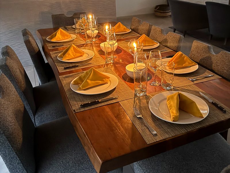 A long dinner table set with candles in a villa in Playas del Coco