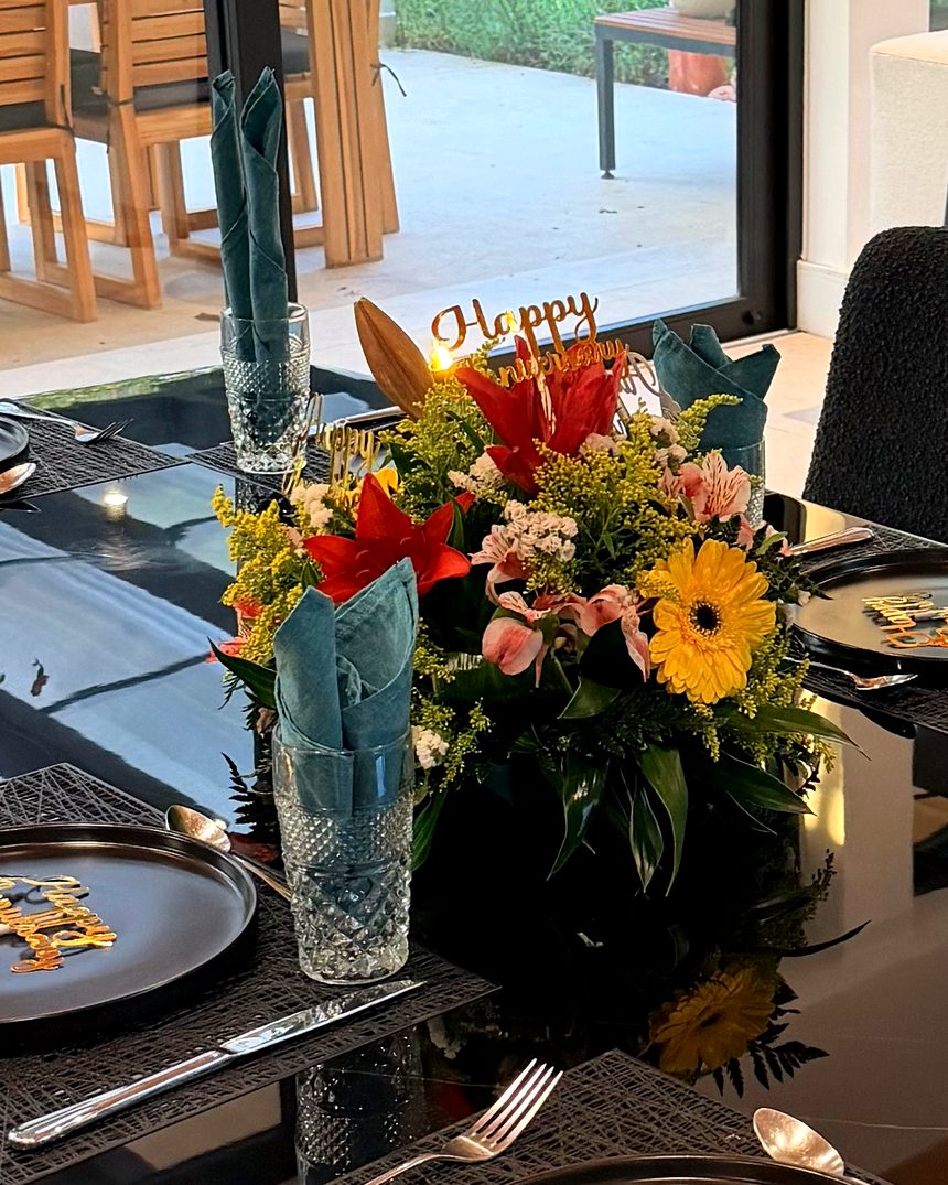 A dinner table set with flowers and turquoise napkins in a villa in Guanacaste